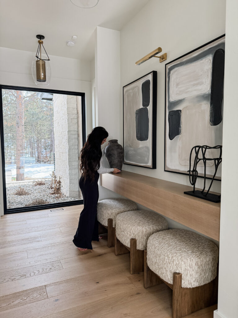Woman styling vase in hallway.