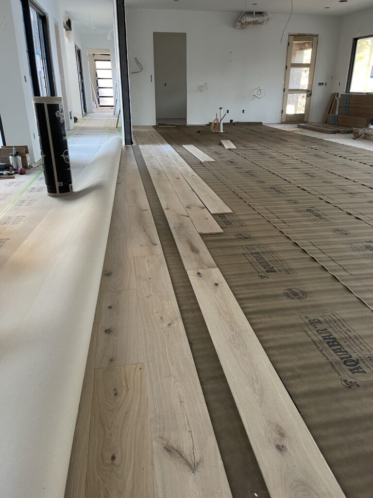 Engineered hardwood floors being installed.